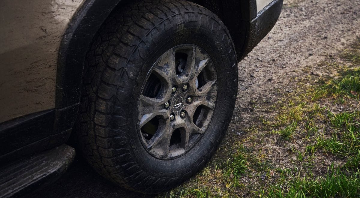 2025 Lexus GX550 Overtrail SUV with 33-inch all-terrain tires, off-road bumpers, and rugged Overtrail design package parked on rocky desert terrain.
