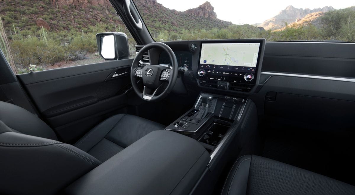 2025 Lexus GX550 Overtrail SUV with 33-inch all-terrain tires, off-road bumpers, and rugged Overtrail design package parked on rocky desert terrain.