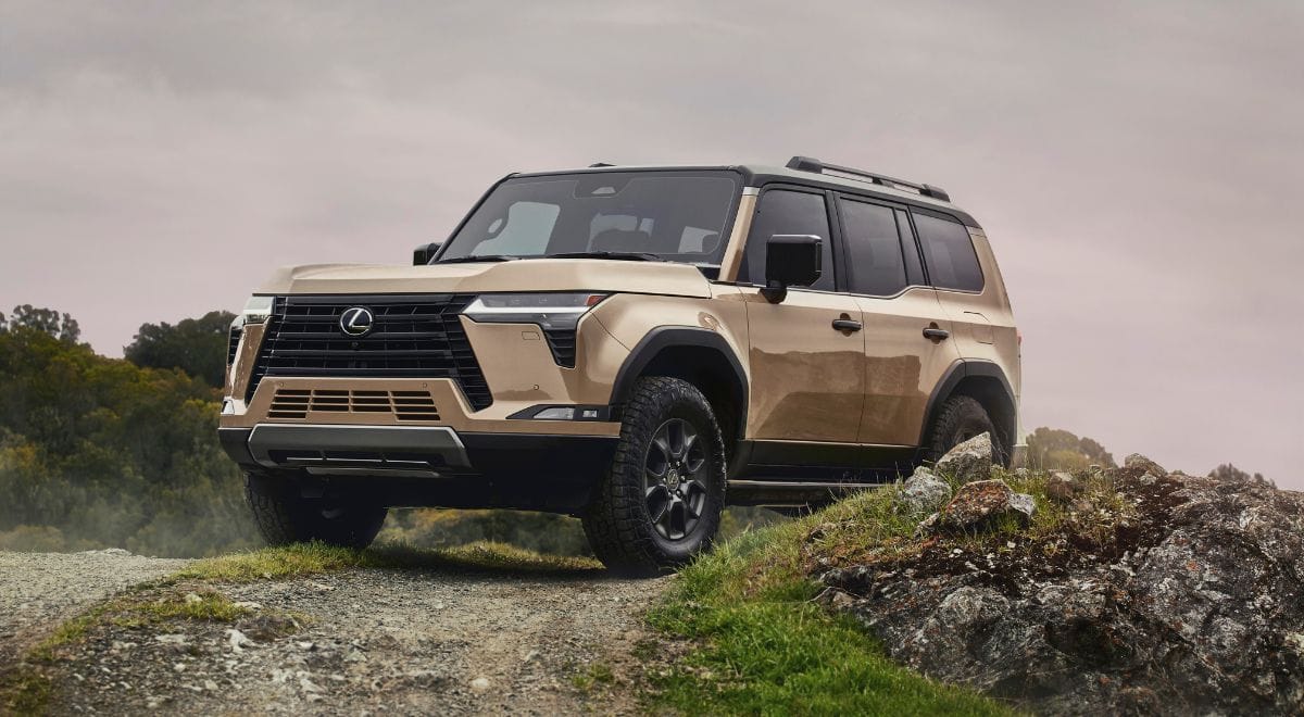 2025 Lexus GX550 Overtrail SUV with 33-inch all-terrain tires, off-road bumpers, and rugged Overtrail design package parked on rocky desert terrain.